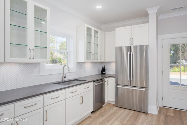 115 Seagate Pl, Wilmington, NC 28403 - kitchen with stainless steel appliances, a sink, dark countertops, white cabinets, and crown molding