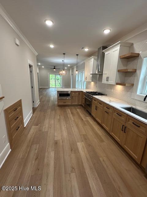 115 Seagate Pl, Wilmington, NC 28403 - kitchen with wall chimney range hood, a sink, a peninsula, stainless steel microwave, and open shelves
