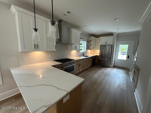 115 Seagate Pl, Wilmington, NC 28403 - kitchen featuring appliances with stainless steel finishes, wall chimney exhaust hood, open shelves, a sink, and a peninsula