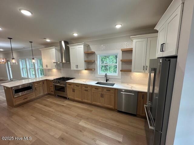 115 Seagate Pl, Wilmington, NC 28403 - kitchen featuring premium appliances, a sink, open shelves, wall chimney range hood, and a peninsula