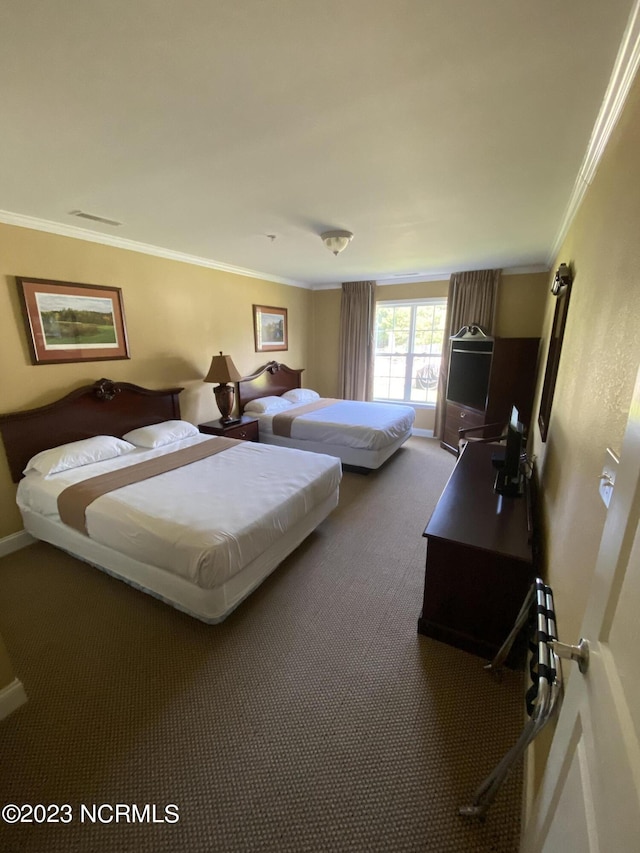 bedroom featuring baseboards, visible vents, ornamental molding, and carpet flooring