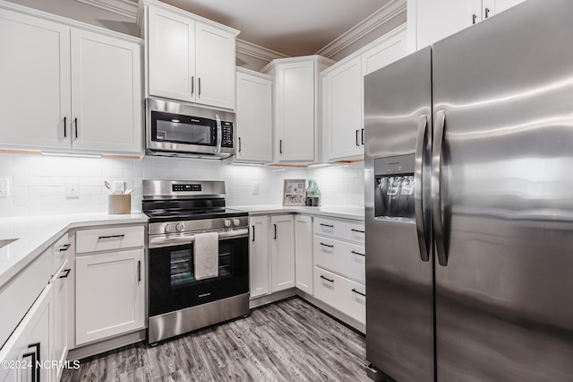 kitchen with light wood-type flooring, backsplash, stainless steel appliances, and white cabinetry