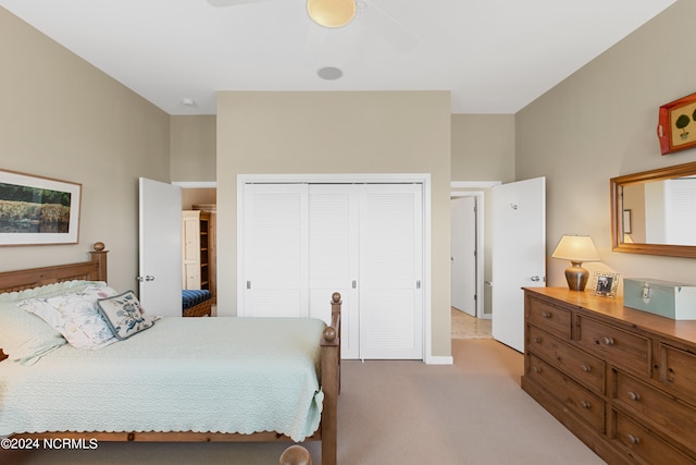 bedroom featuring light colored carpet, a closet, and ceiling fan