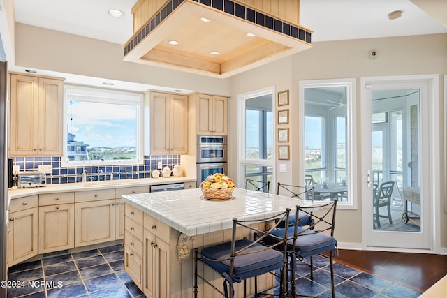 kitchen with light brown cabinets, dark hardwood / wood-style flooring, tasteful backsplash, and tile countertops