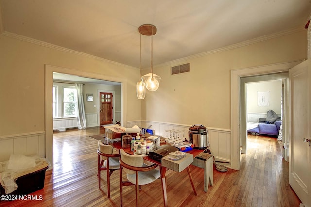 dining space featuring crown molding and wood-type flooring