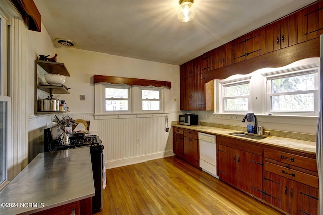 kitchen featuring sink, light wood-type flooring, dishwasher, and black gas stove