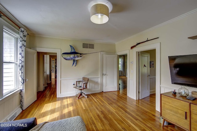 interior space featuring ornamental molding and light hardwood / wood-style flooring