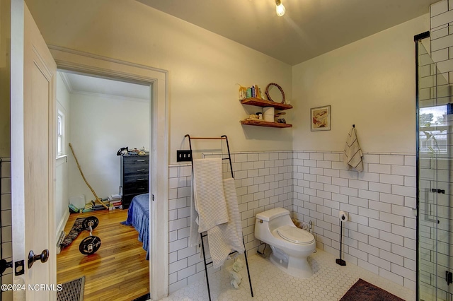 bathroom featuring tile patterned flooring, tile walls, and toilet