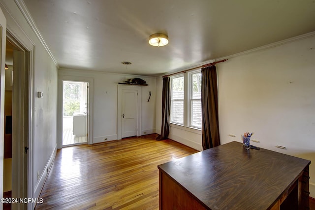 unfurnished office featuring ornamental molding and light hardwood / wood-style floors