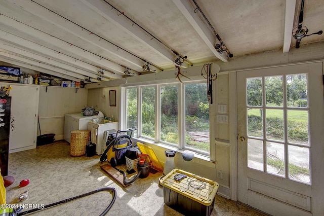 sunroom / solarium featuring plenty of natural light, washing machine and dryer, and vaulted ceiling