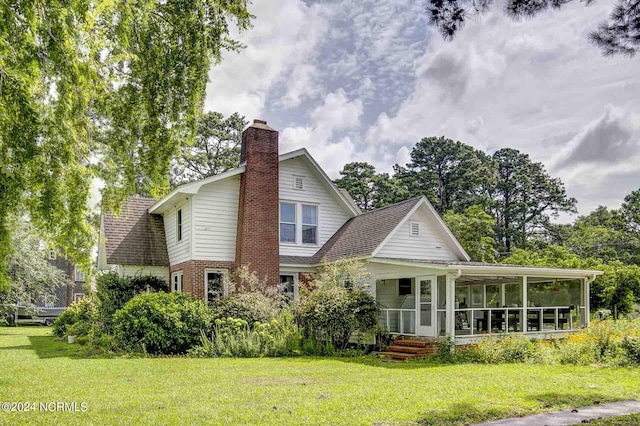 264 Main St, Swanquarter, NC 27885 - back of house with a sunroom, a yard, brick siding, and a chimney