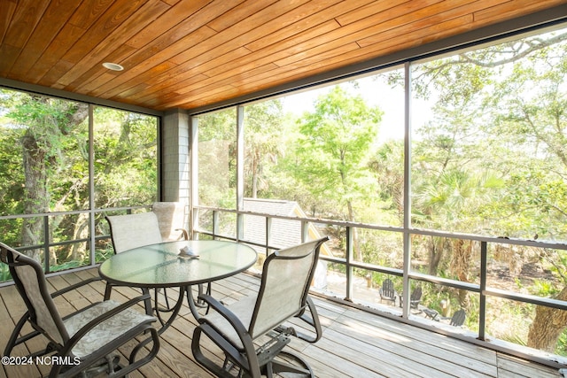 sunroom featuring wood ceiling and plenty of natural light