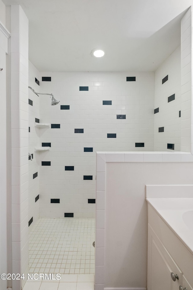 bathroom with vanity and a tile shower