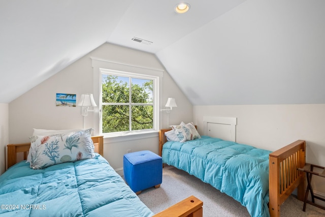 bedroom featuring lofted ceiling and light carpet