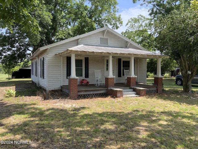 view of front of house with a porch and a front yard