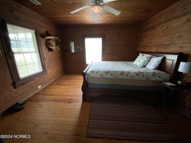 unfurnished bedroom with wood ceiling, ceiling fan, multiple windows, and wood walls