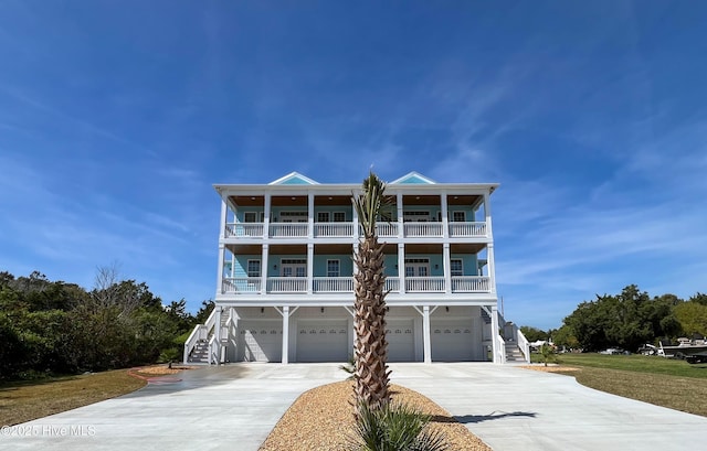 244 Grandview Dr, Sneads Ferry, NC 28460 - coastal inspired home featuring an attached garage, driveway, stairs, and a balcony