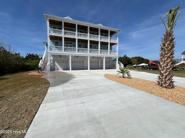 244 Grandview Dr, Sneads Ferry, NC 28460 - raised beach house featuring driveway, stairway, an attached garage, and a balcony
