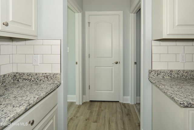 244 Grandview Dr, Sneads Ferry, NC 28460 - kitchen featuring light wood finished floors, decorative backsplash, light stone counters, baseboards, and white cabinets