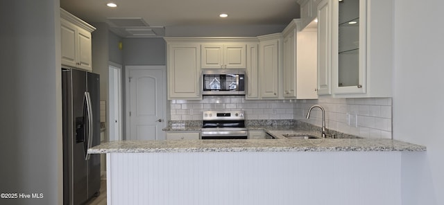 244 Grandview Dr, Sneads Ferry, NC 28460 - kitchen with stainless steel appliances, decorative backsplash, a peninsula, and a sink