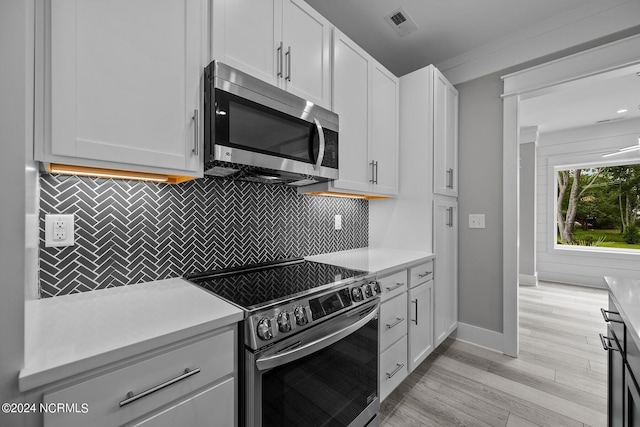 kitchen featuring backsplash, light hardwood / wood-style flooring, stainless steel appliances, and white cabinets