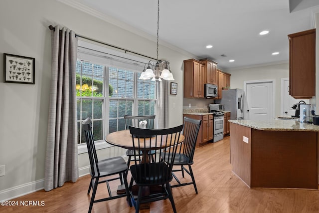 kitchen with appliances with stainless steel finishes, sink, ornamental molding, light hardwood / wood-style floors, and light stone countertops