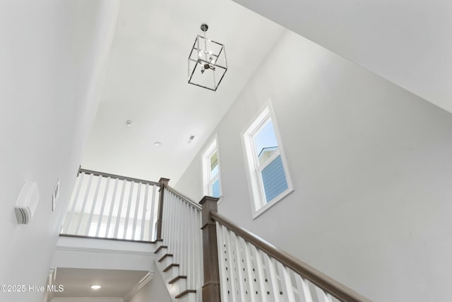 staircase featuring a towering ceiling and a healthy amount of sunlight