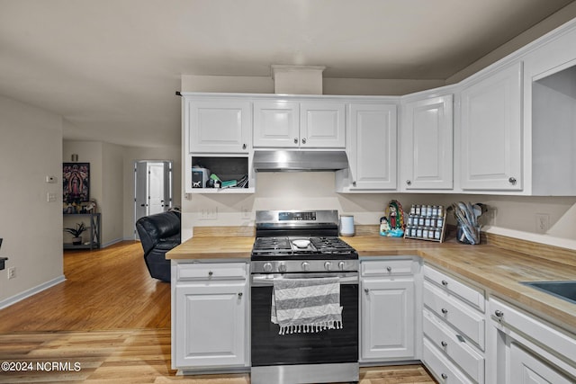 kitchen featuring white cabinetry, stainless steel gas range oven, wooden counters, and light wood-type flooring