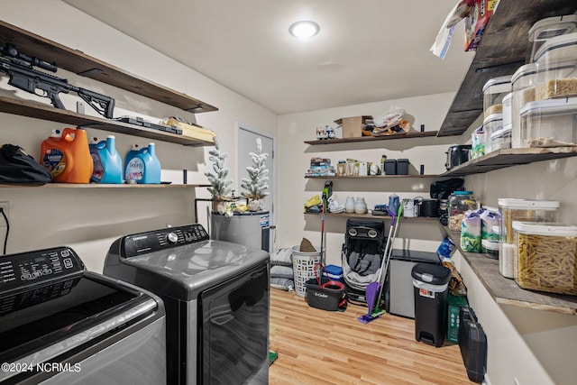 laundry area with washer and dryer and light hardwood / wood-style flooring