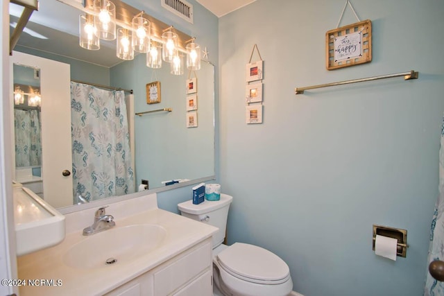 bathroom with toilet, curtained shower, vanity, and visible vents