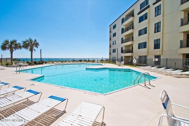 pool with a patio area and fence