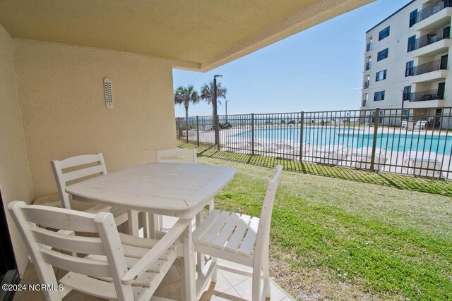 exterior space with a balcony and a community pool