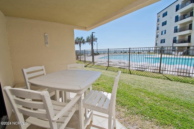 view of patio / terrace with a community pool and fence