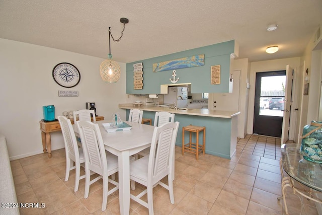 dining space featuring light tile patterned floors and a textured ceiling