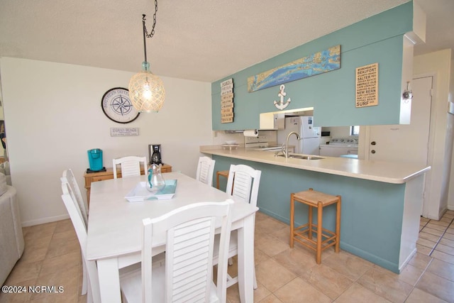 dining room with a textured ceiling, washer and clothes dryer, and light tile patterned floors