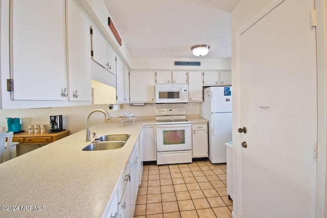 kitchen featuring light tile patterned floors, white appliances, a sink, white cabinetry, and light countertops