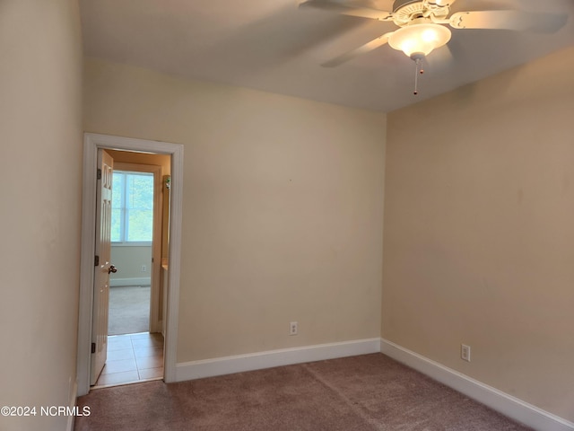 carpeted spare room with ceiling fan