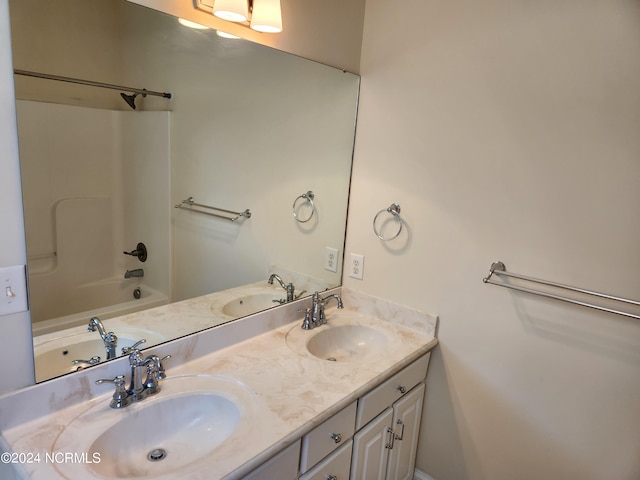 bathroom featuring vanity and  shower combination