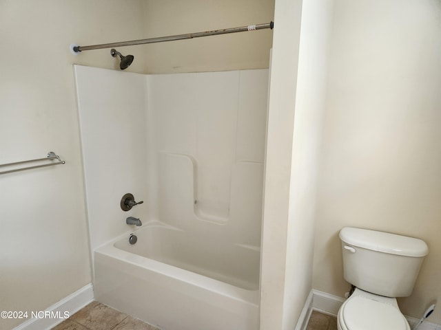 bathroom featuring tile patterned flooring, tub / shower combination, and toilet