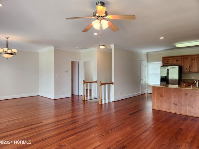 unfurnished living room with ornamental molding, ceiling fan with notable chandelier, dark hardwood / wood-style floors, and sink