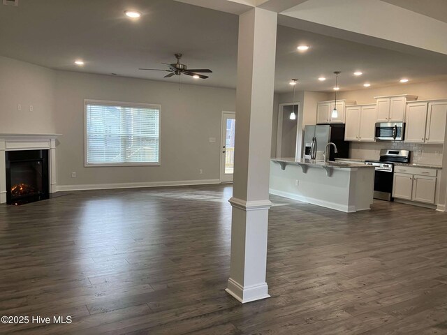 living room with dark wood-type flooring and ceiling fan