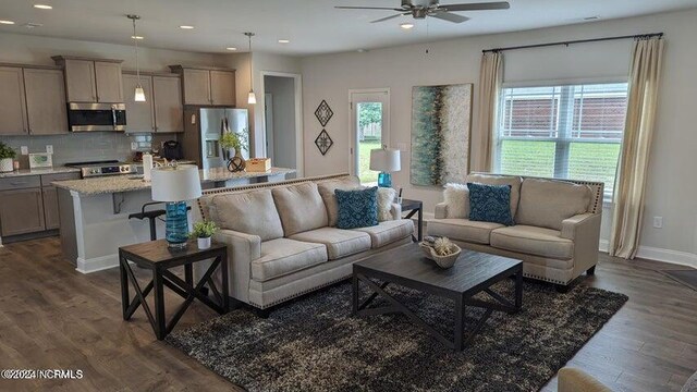 living room featuring dark hardwood / wood-style floors and ceiling fan