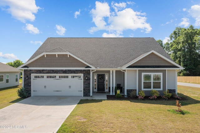 craftsman-style house with an attached garage, a shingled roof, driveway, stone siding, and a front yard