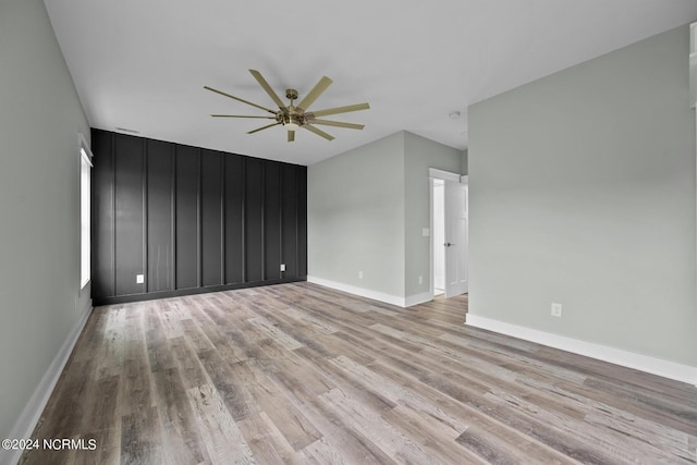 empty room with light hardwood / wood-style flooring and ceiling fan