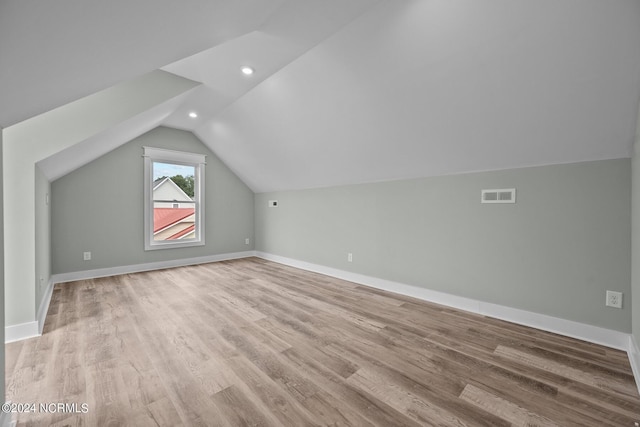 additional living space with lofted ceiling and light hardwood / wood-style floors