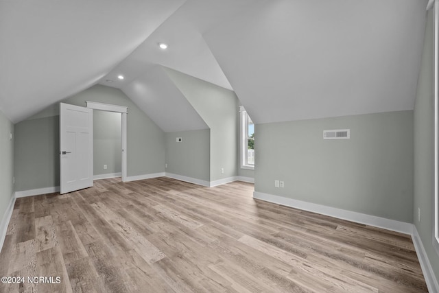 additional living space featuring lofted ceiling and light hardwood / wood-style floors