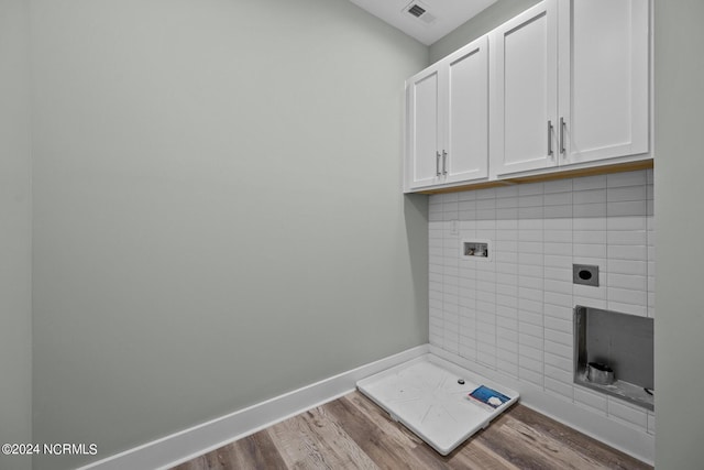 washroom featuring cabinets, washer hookup, hookup for an electric dryer, and light wood-type flooring