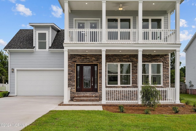 view of front facade with a garage, a balcony, covered porch, and a front lawn