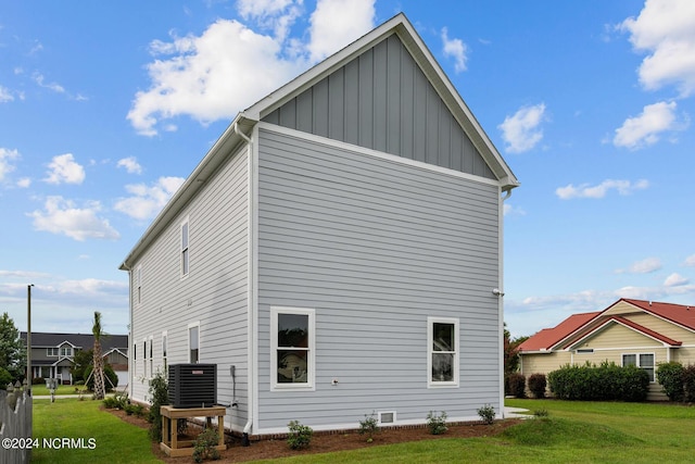 view of side of home featuring a lawn and central air condition unit