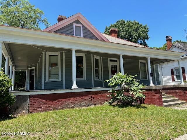 view of front facade featuring a front lawn and covered porch